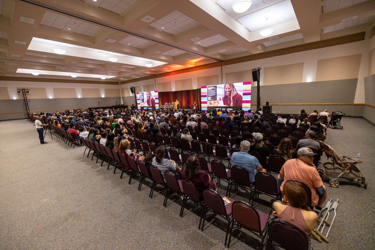 Group of people sitting in audience watching presentation