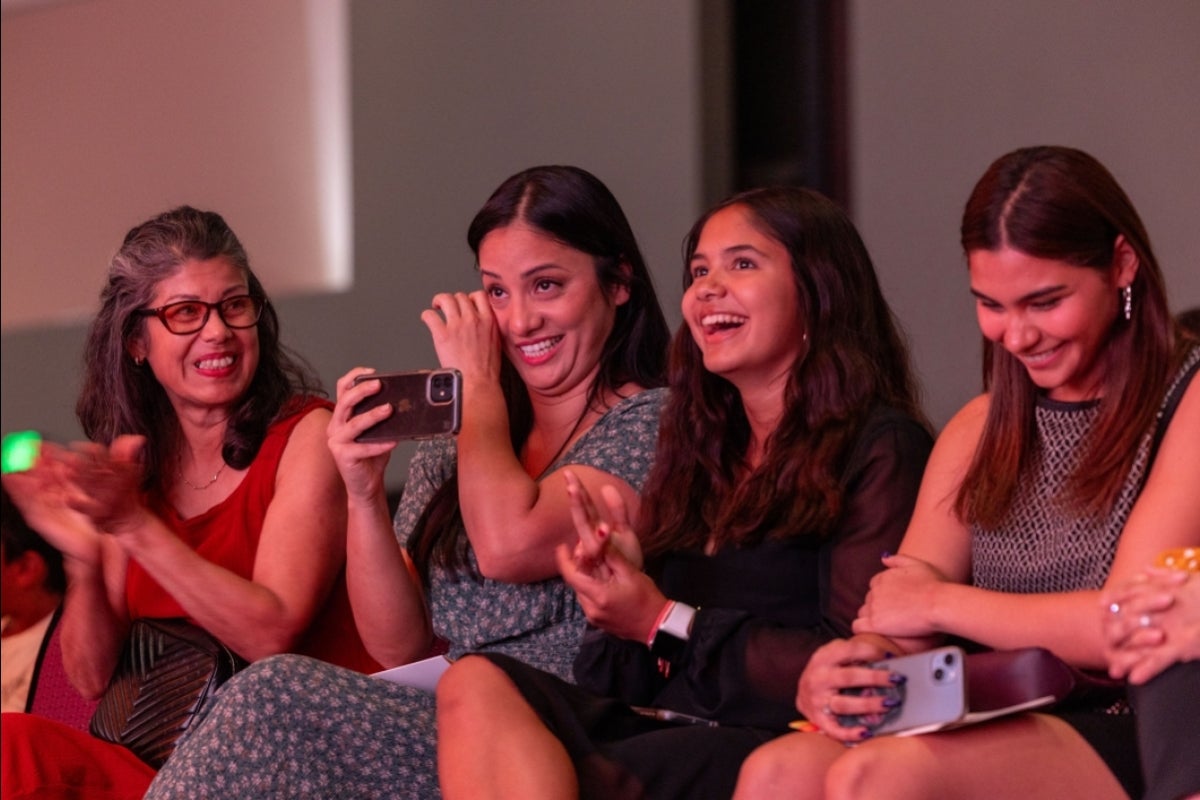 Woman in audience watching film wiping away tears