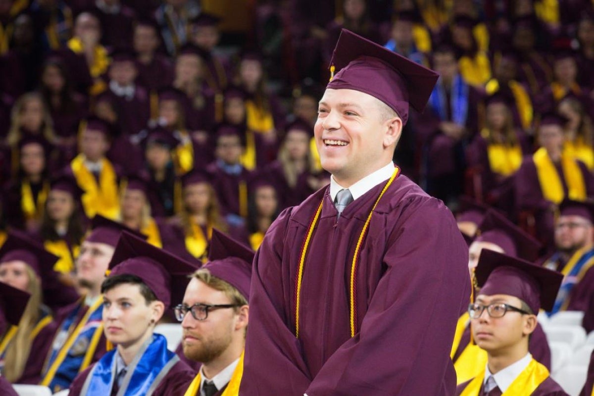 student standing at graduation