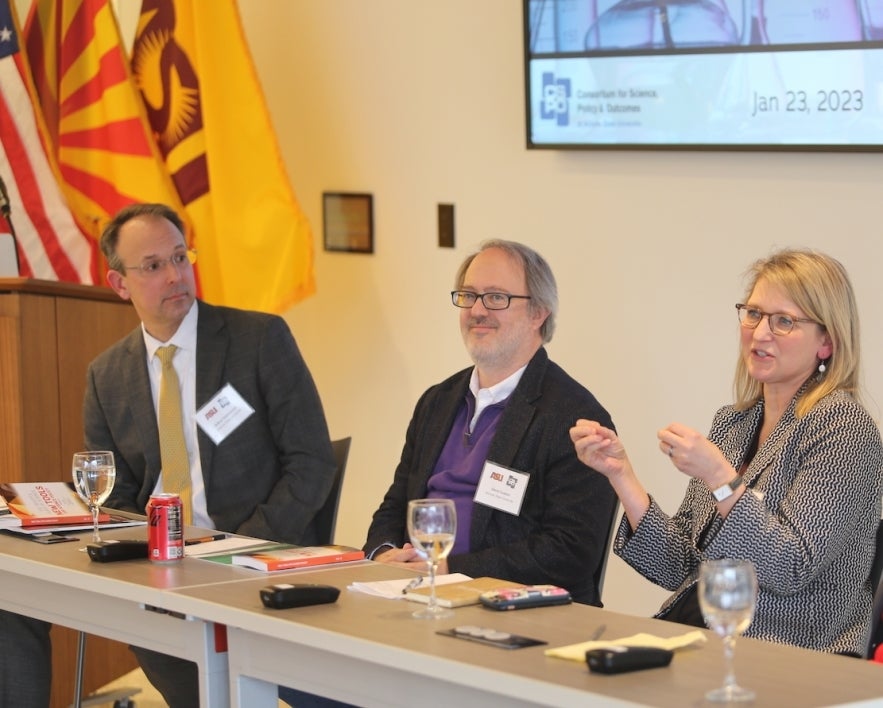 Experts in a discussion, sitting alongside each other at a table.