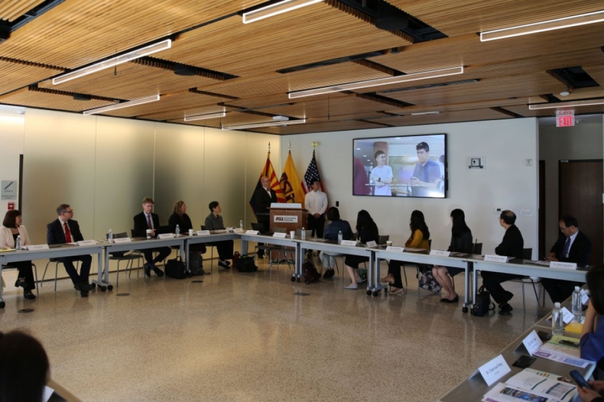 People sit at conference tables in a square shape