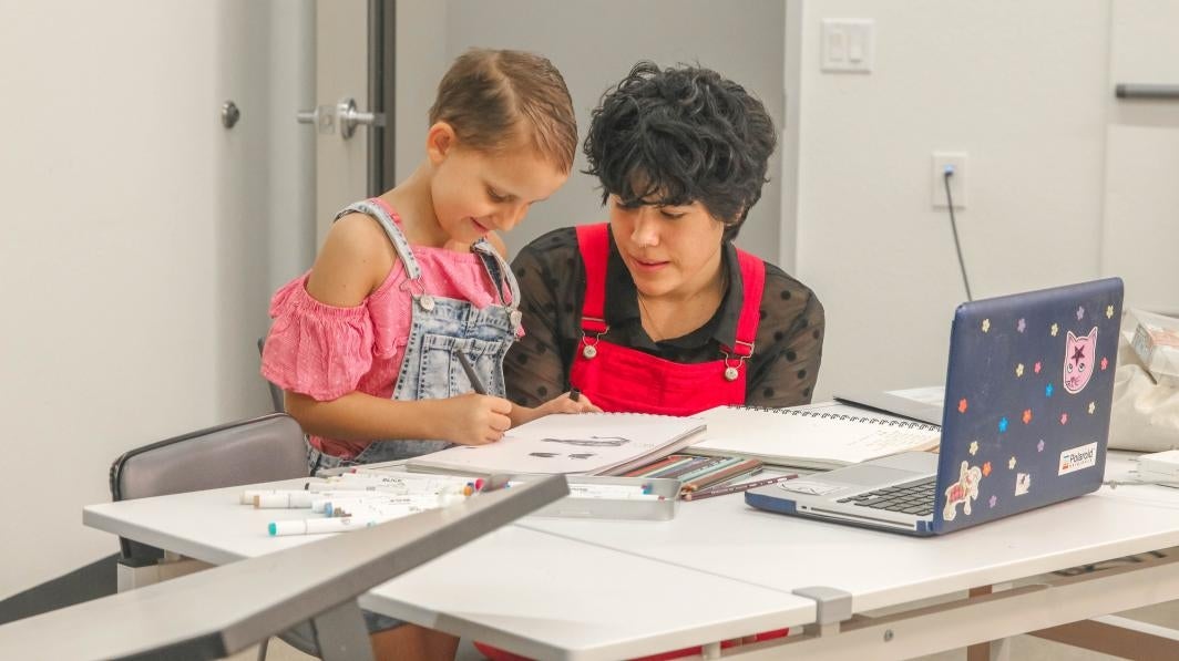 A Phoenix Children's Hospital patient works with a designer from ASU's Fashion Lab on her Power Play costume