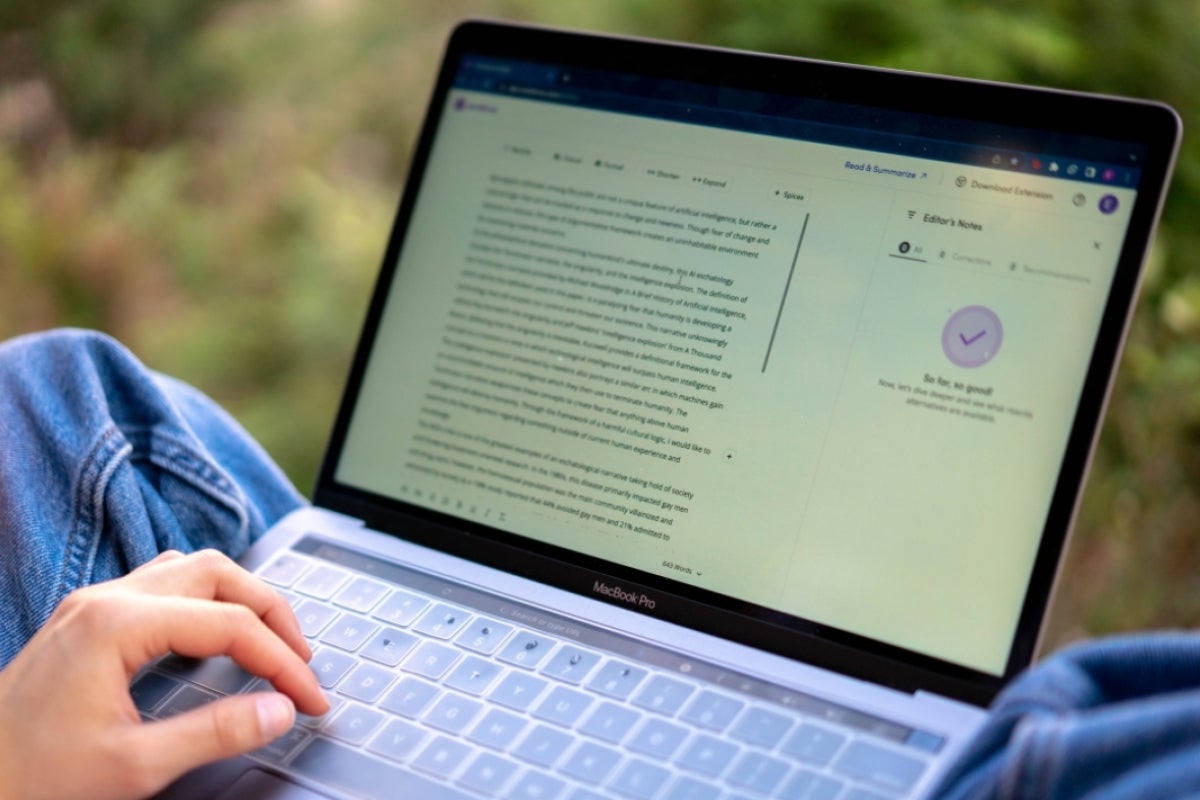 A laptop and a person's hand hovering over the keyboard.