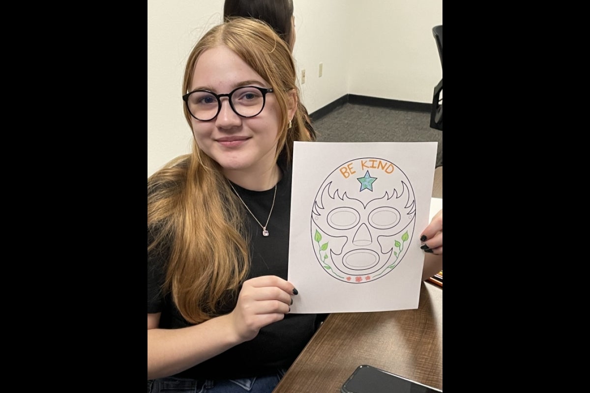 Student showing mask artwork