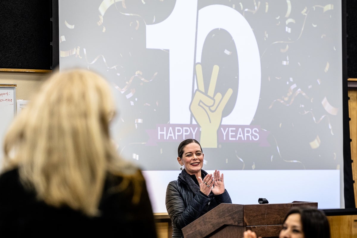 Woman clapping at podium