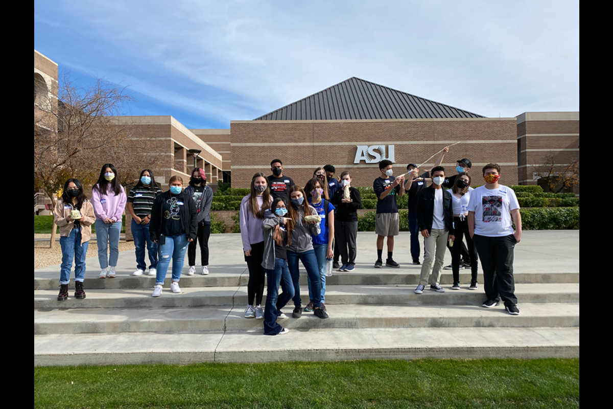 ASU Prep Digital students standing on a staircase holding prototypes they made on ASU's West campus.