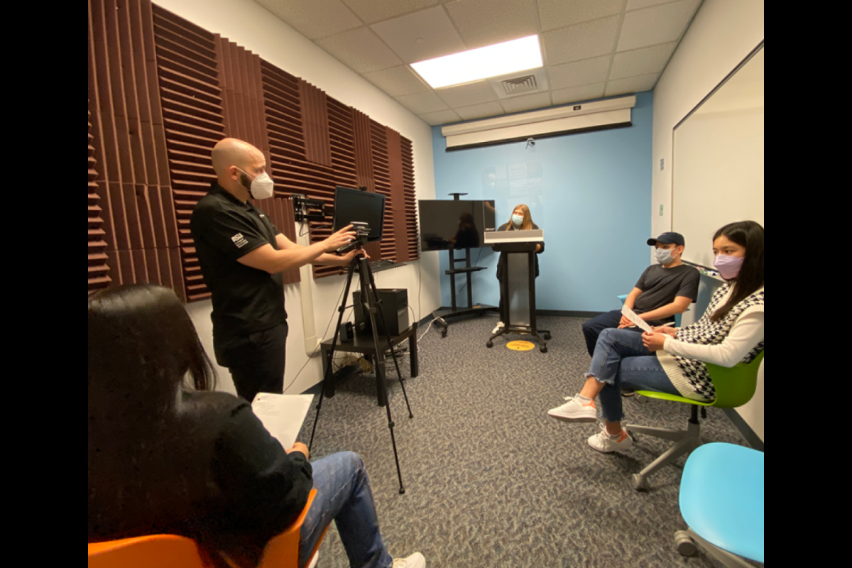 Students and an instructor gathered in a sound-proof room.