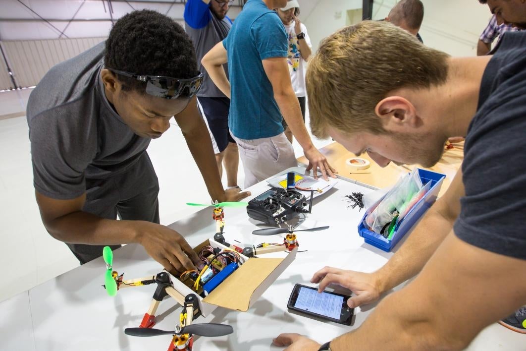 Aviation students work on a cardboard drone.