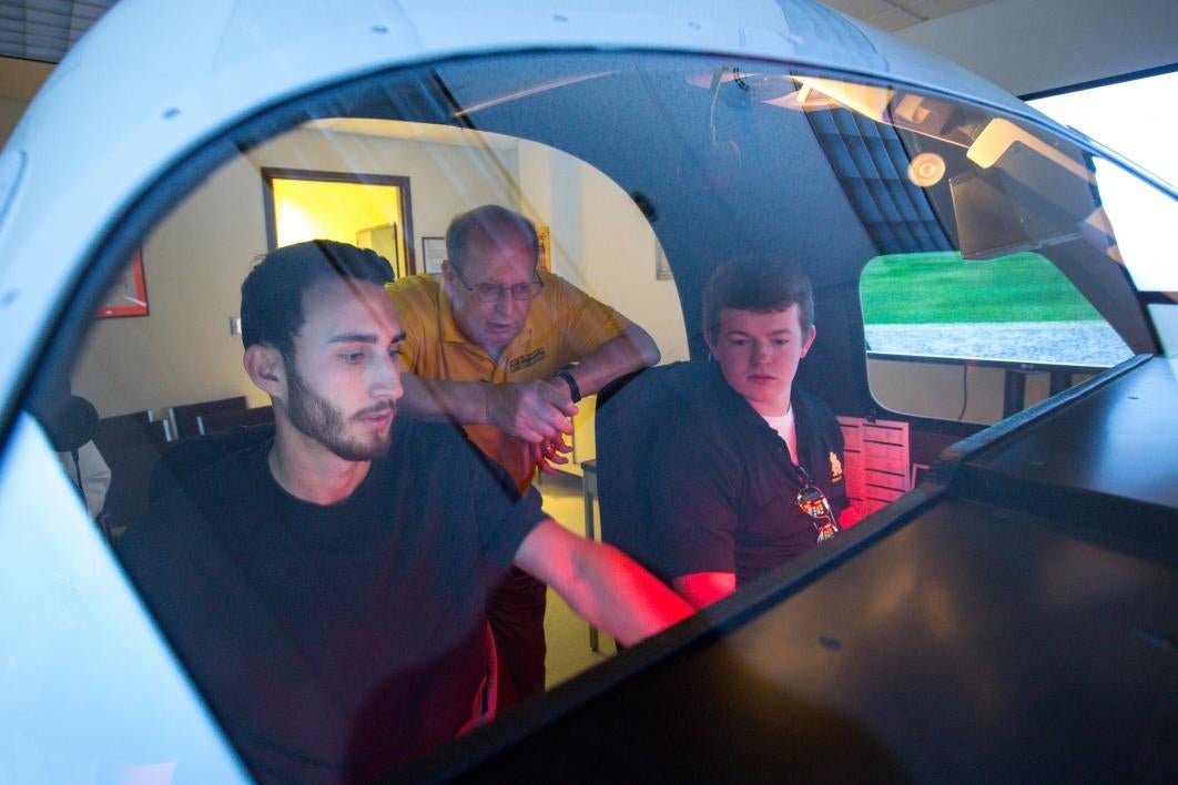 Aviation students in a flight simulator.