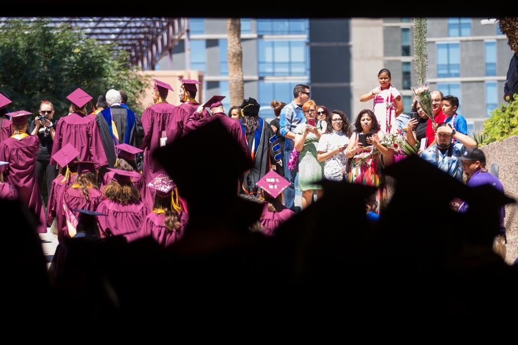 people waiting for graduates to exit building