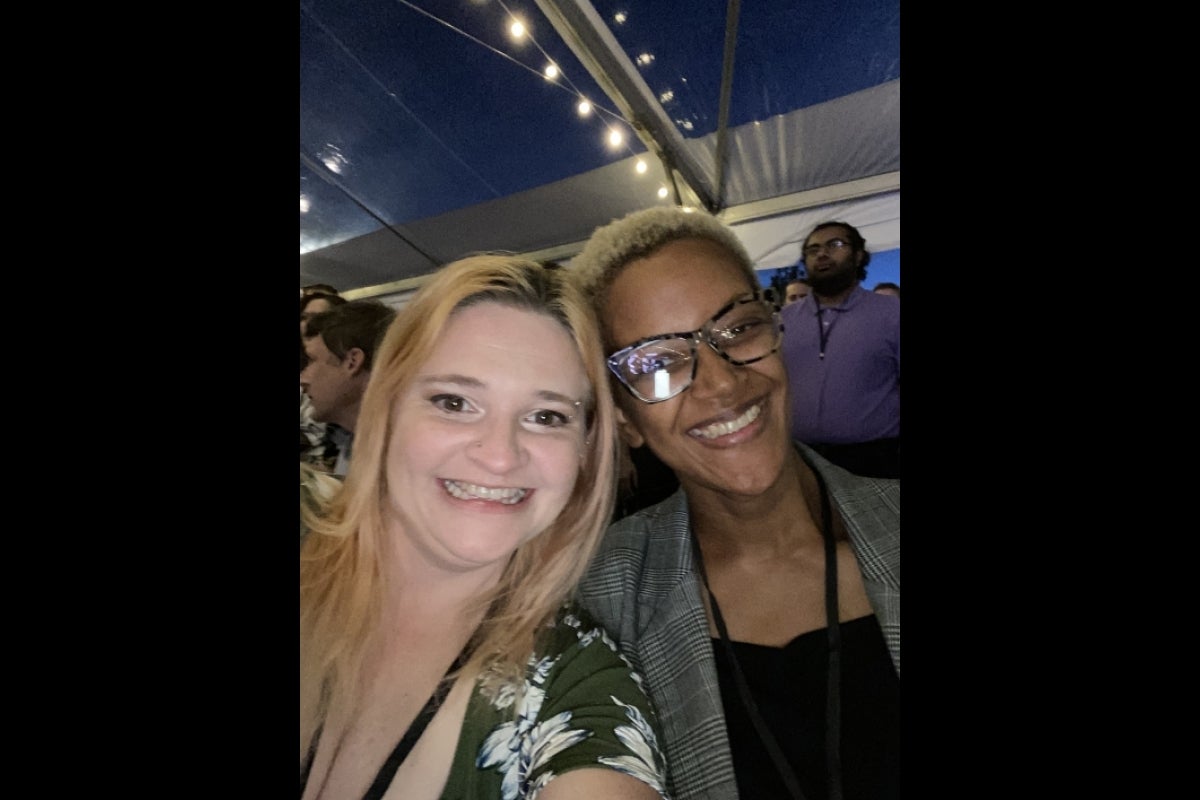 Two women smile widely at the camera.