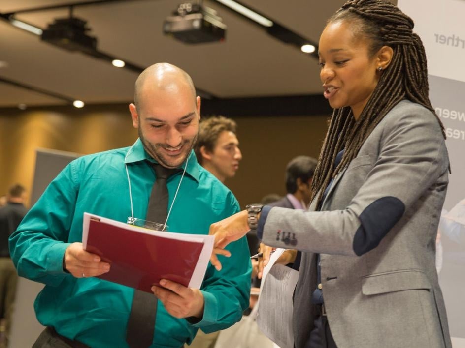 A recruiter looks over a student's résumé. Students were seeking internships and full-time jobs. Following the career fair, students interviewed with employers on campus for jobs and internships. Photographer: Jessica Hochreiter/ASU