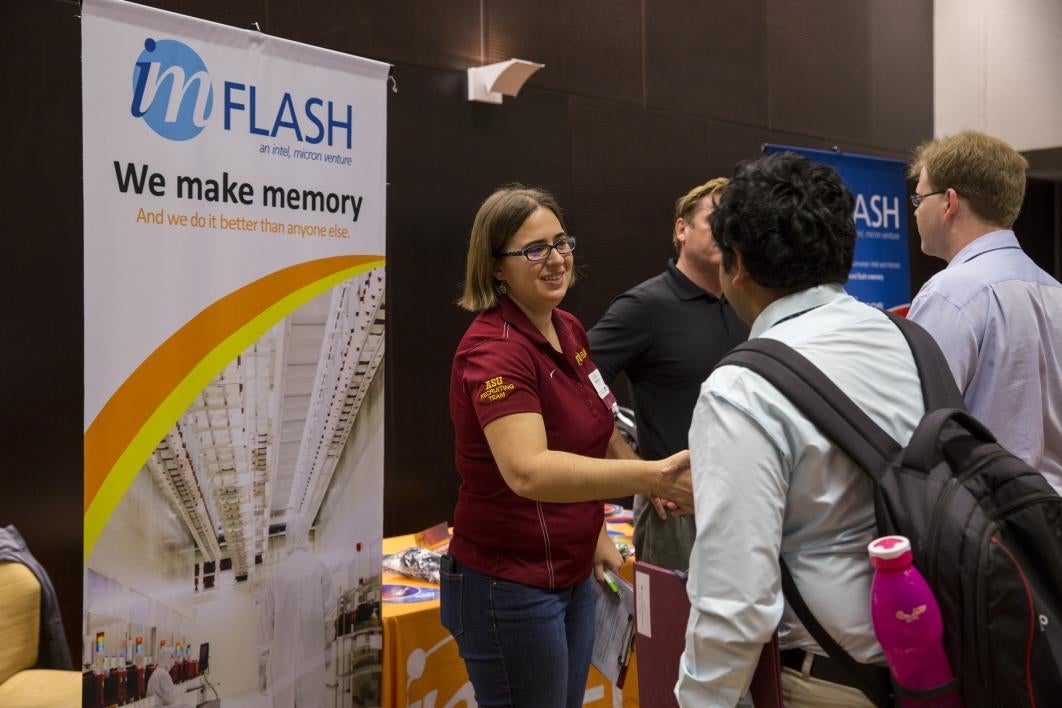 woman shaking hands with student at career fair