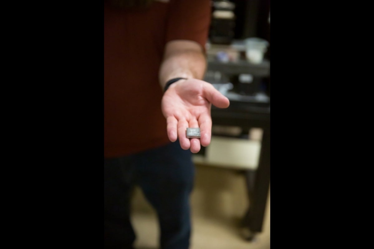 Outstretched hand holding a glass sample that is used for various testing purposes.