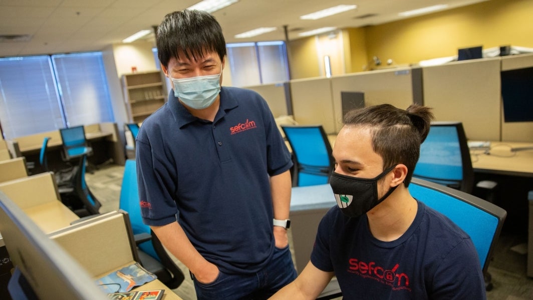 Ruyu “Fish” Wang and Zion Basque work in a computer lab.