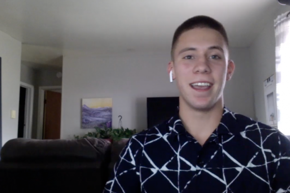 Man seated in a living room speaking into a webcam.