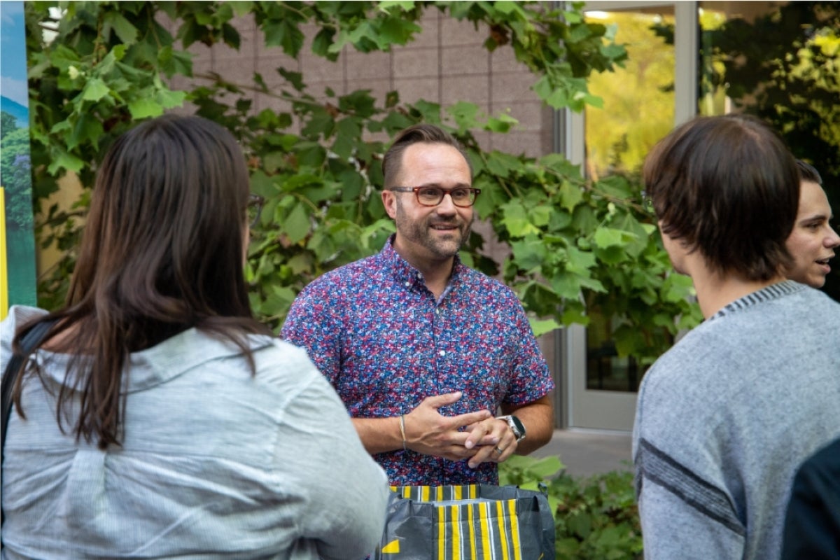 Man speaking to students at an outdoor event.