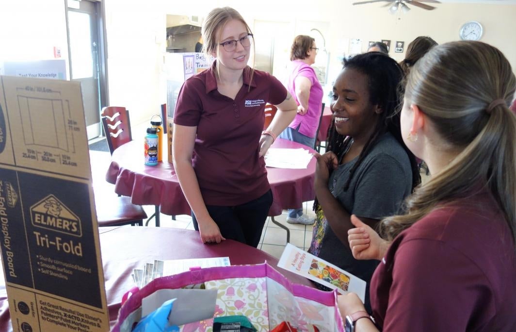 ASU nursing students pose with the poster they created for a health fair