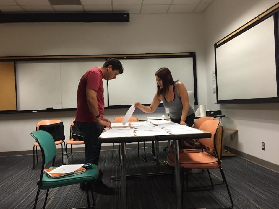 students sorting papers in classroom