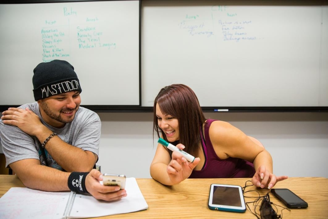 students talking with laptop in classroom