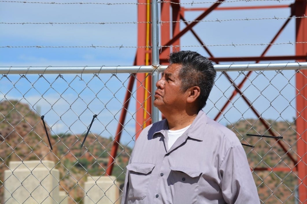 Douglas Miles photographed in front of a chain fence