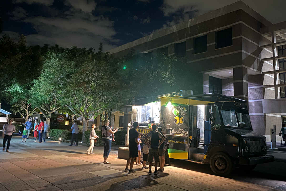 People line up outside a food truck.