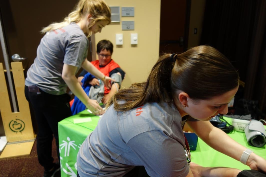 Nursing students Emily Fadley and Madeline Aaron take athletes blood pressure