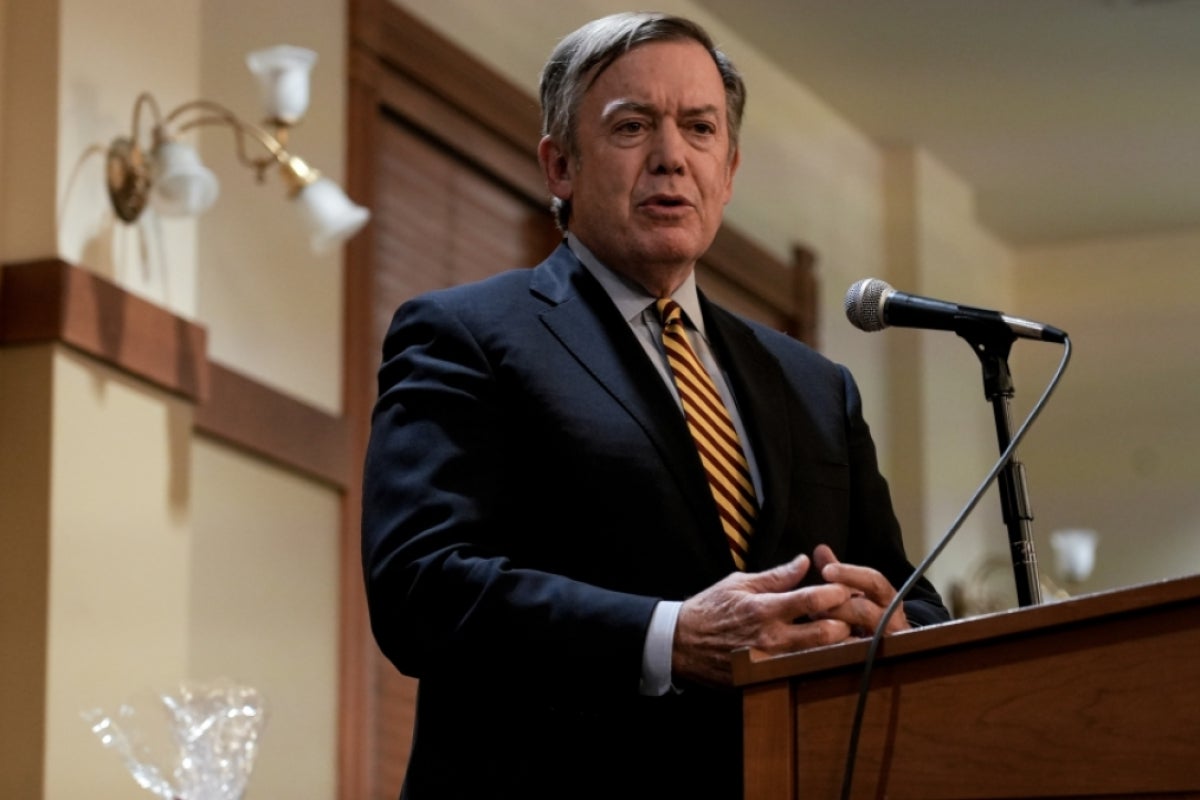 ASU President Crow speaks behind a lectern