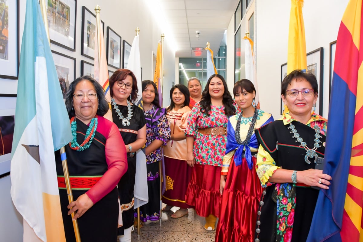 DreamCatcher graduates holding their tribal flags as they walk to their graduation ceremony.