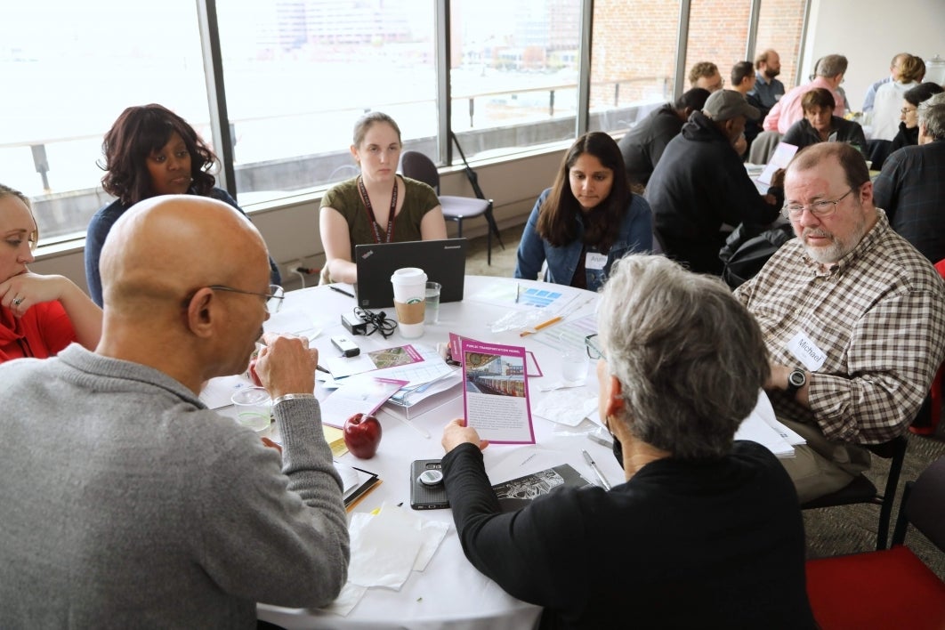 members of the public discuss self-driving cars around a table