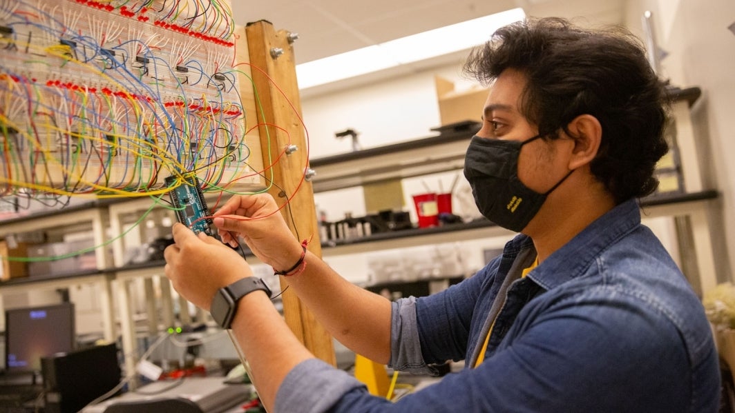 Anand Sengar examines wires in a lab.