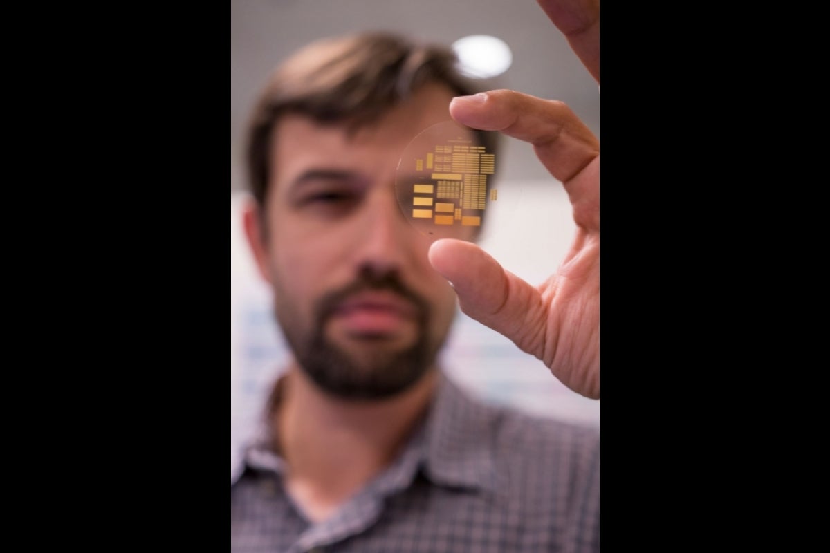 George Trichopoulos holds up a tiny array of many antennas.