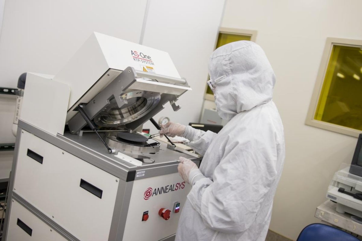 student in protective lab coat working in lab