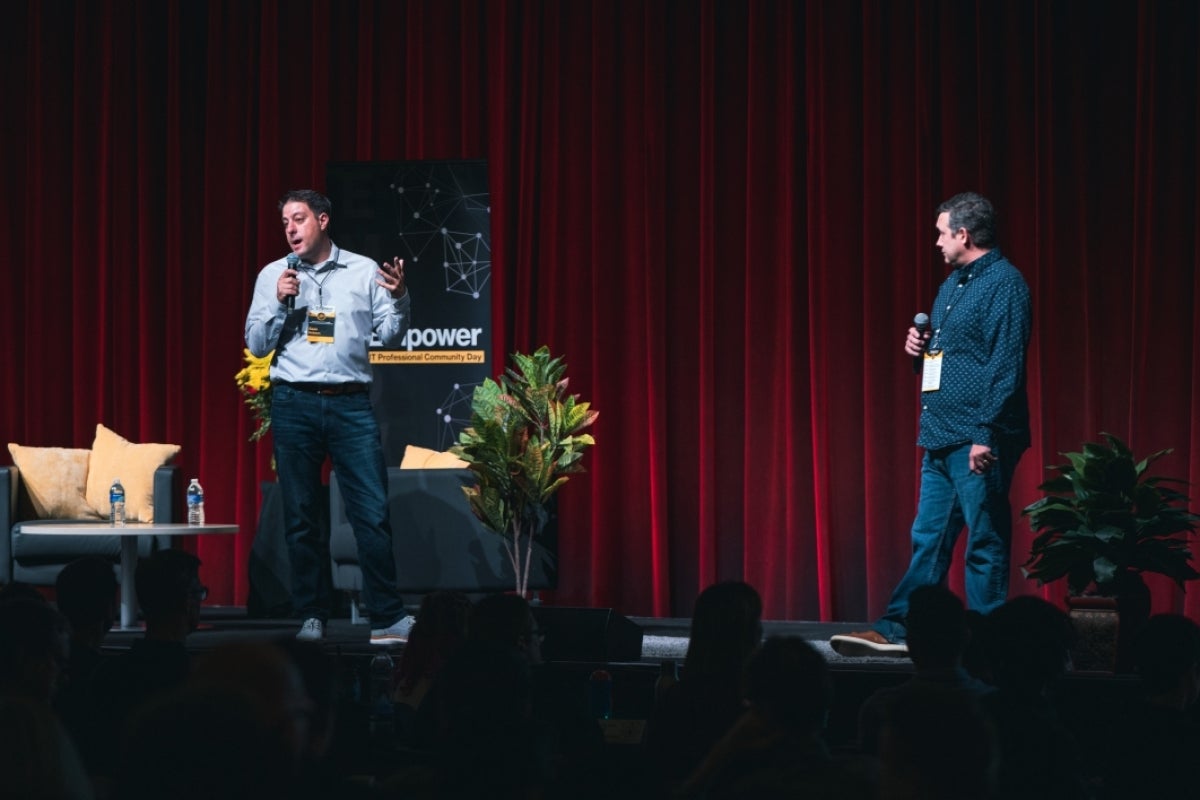 Wayne Anderson and Sean Hobson standing on stage holding microphones.