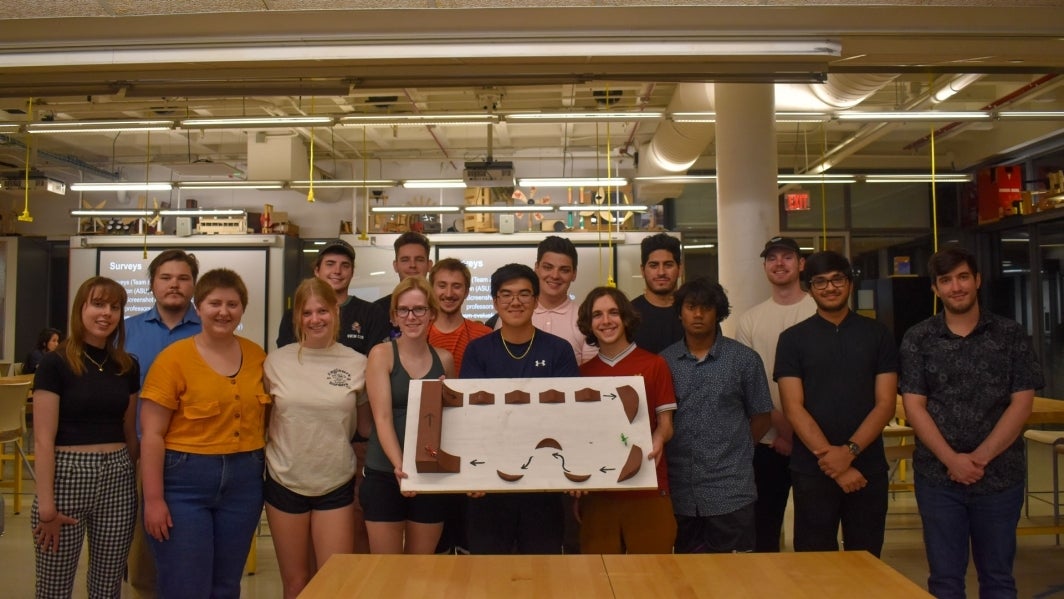 EPICS Navajo Mountain Bike student team holding their prototype in a classroom.