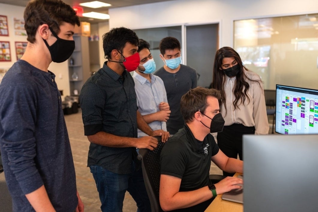 Students watching CIC intern Nilo Exar on computer.