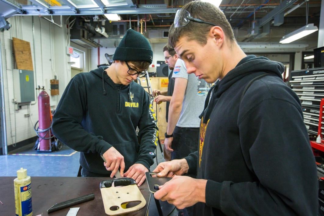 Students work on a steering wheel.