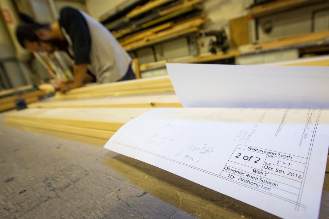 A student constructs a play's scenery.