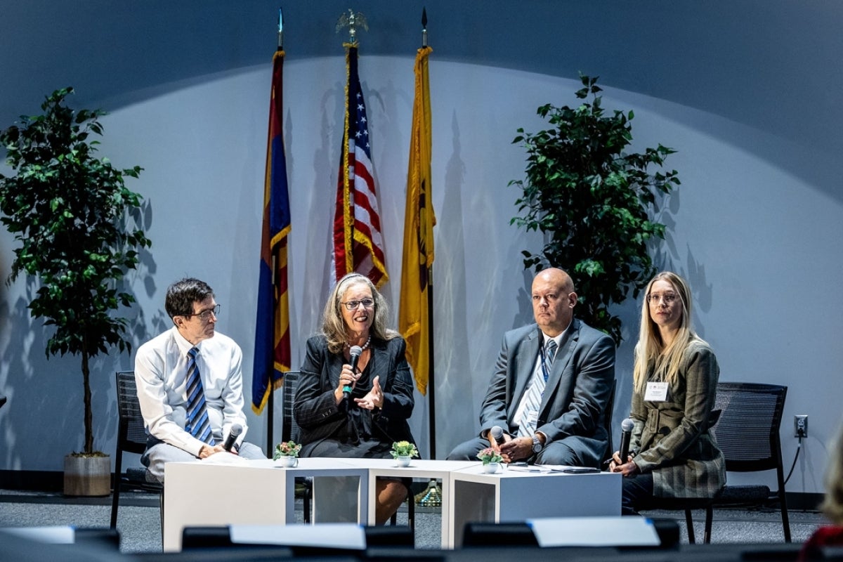 Four people seated on a stage.