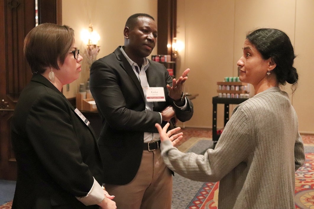 people wearing name tags, smiling and chatting at a networking event