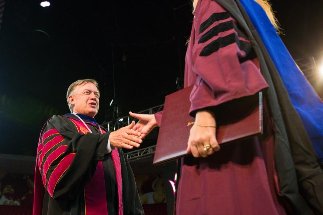 College people congratulate each other while wearing odd clothes.