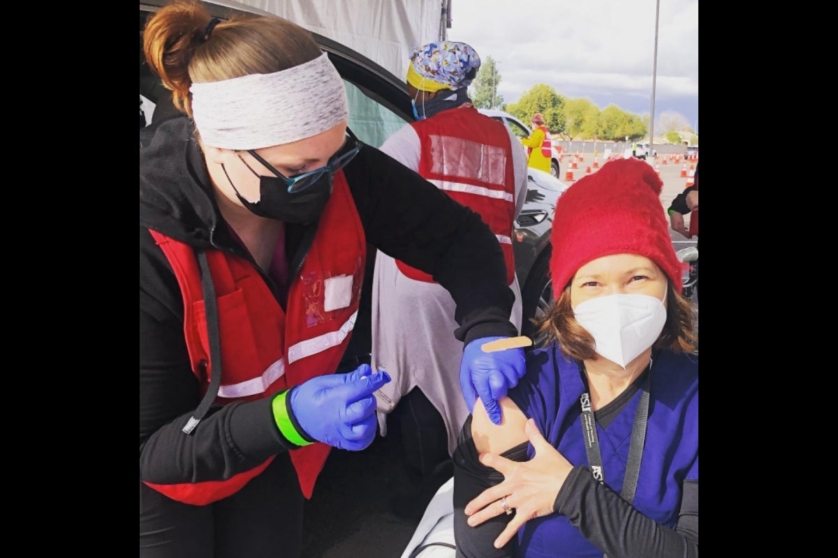 Edson College faculty member Heidi Sanborn receives the COVID-19 vaccine from an Edson College student