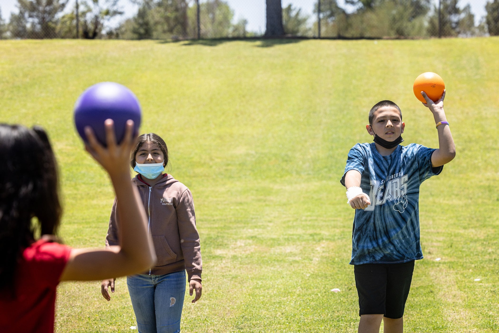 Three students throwing a ball