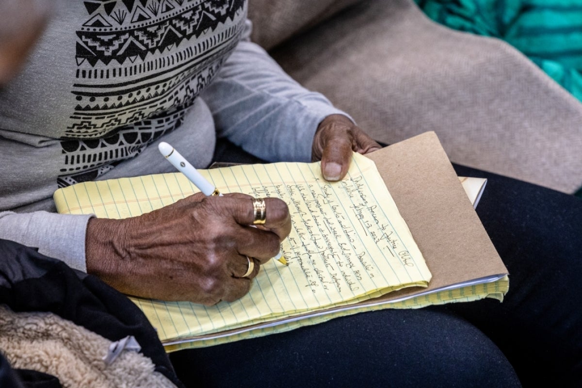 Close-up of a hand writing on a notepad.