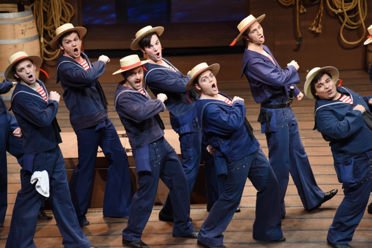 A group of performers in sailor costumes during a show.