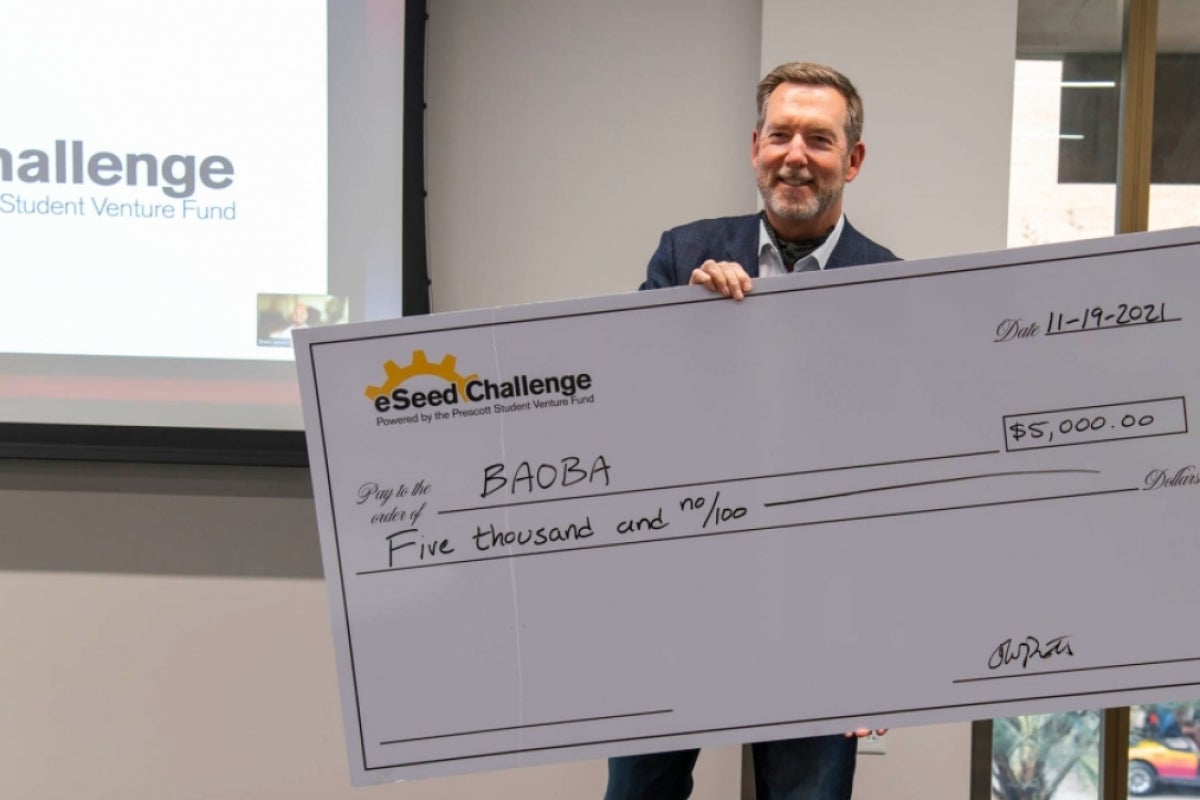 Tom Prescott presents a check for $5,000 for Prudence Zhu’s Baoba Lending startup.