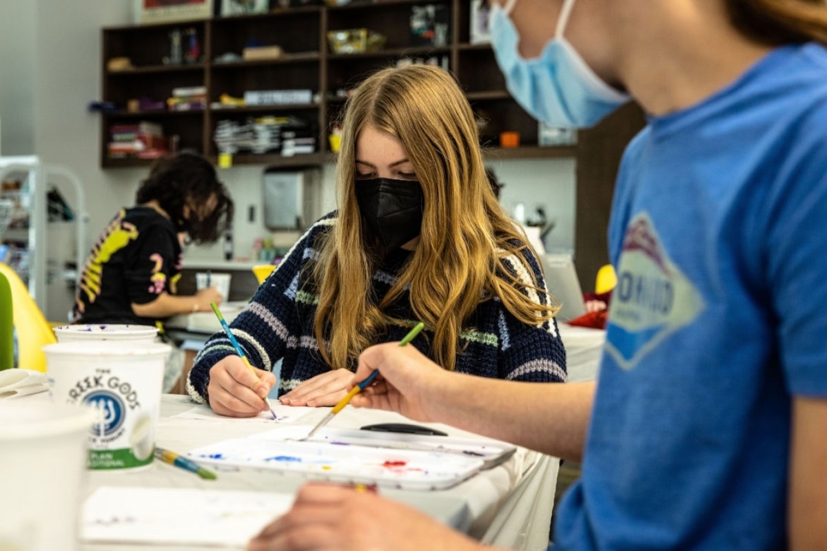 Students painting in a classroom.