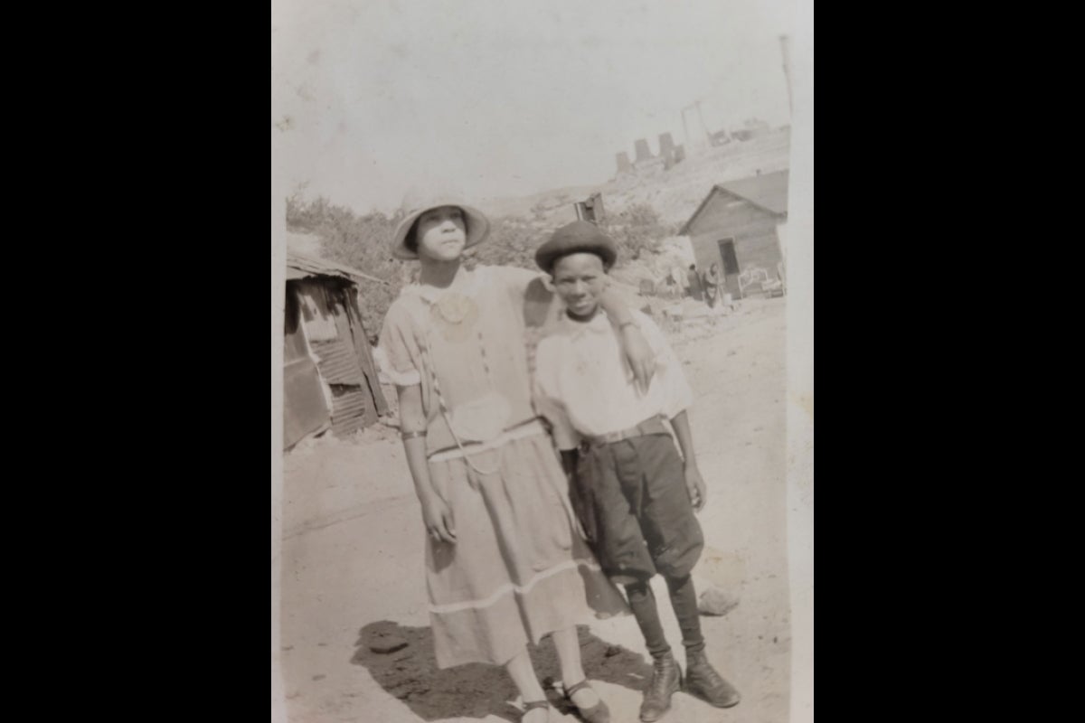 Old black-and-white photo of young African American girl and boy.