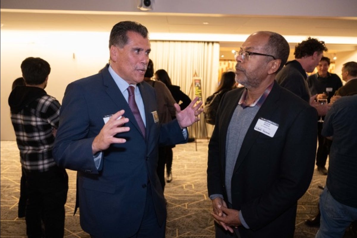 Two men speaking and gesturing with their hands.