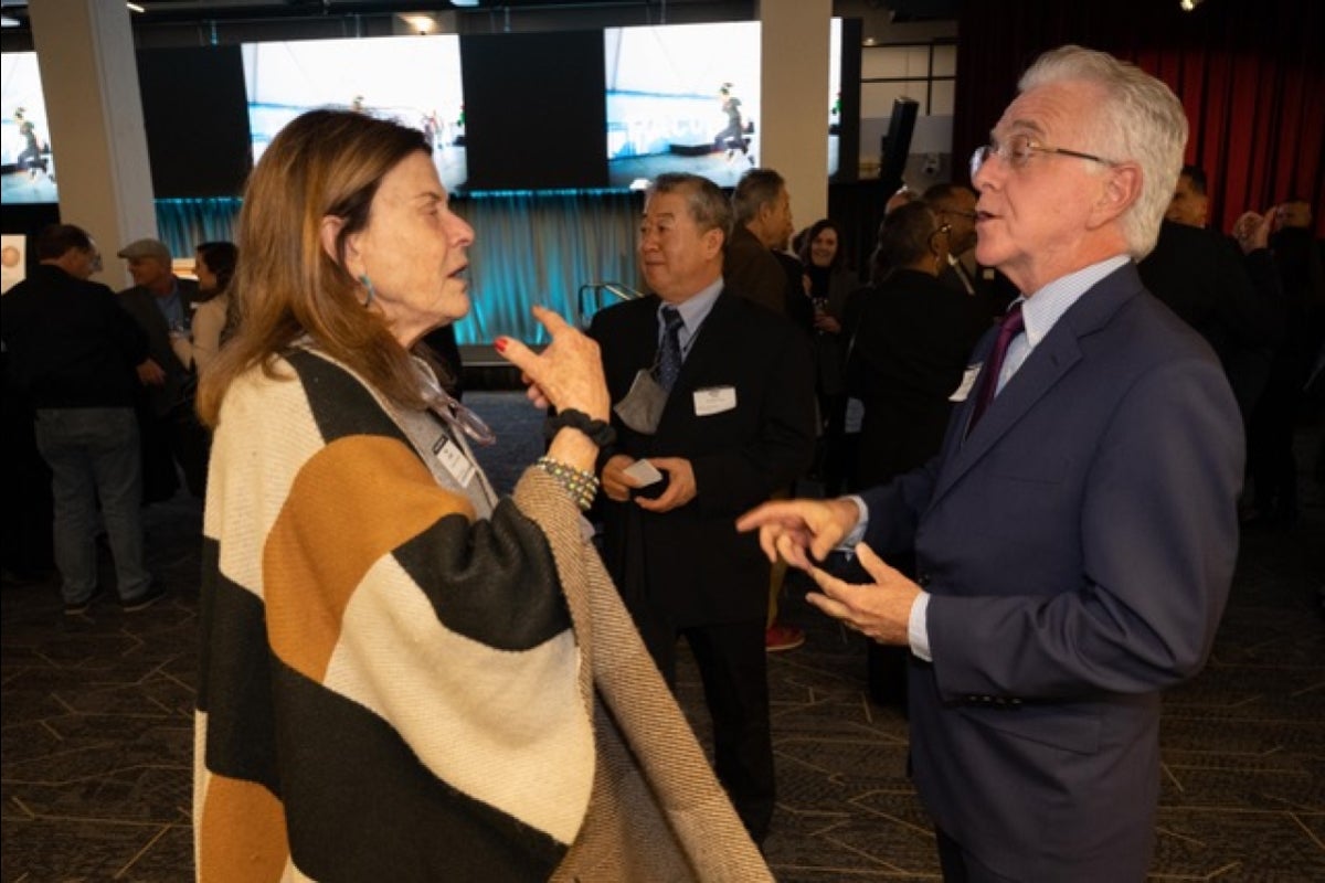 Woman and man gesturing with their hands and speaking to each other.